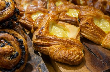 Tahta bir masada kruvasan ve kekler.