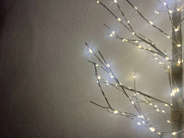 Dallarında ışıklar olan parıldayan dekoratif ağaç, kopyalama alanı, yeni yıl konsepti. 