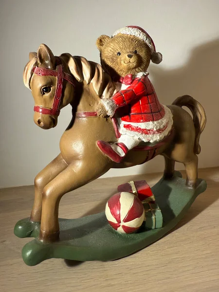 Christmas toy bear on rocking horse with gifts, festive holiday decoration. 