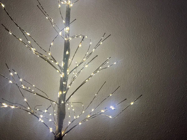Dallarında ışıklar olan parıldayan dekoratif ağaç, kopyalama alanı, yeni yıl konsepti. 