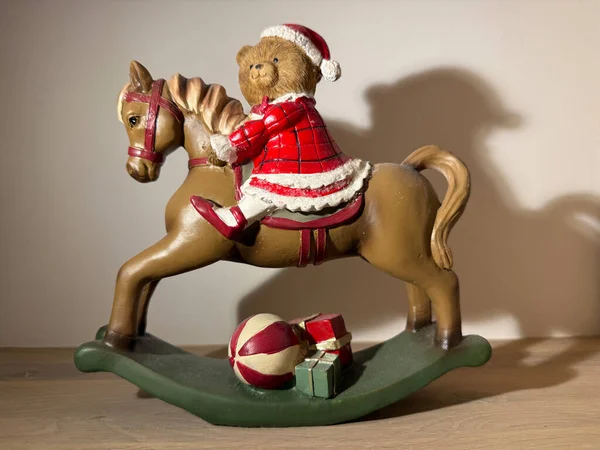 Christmas toy bear on rocking horse with gifts, festive holiday decoration. 