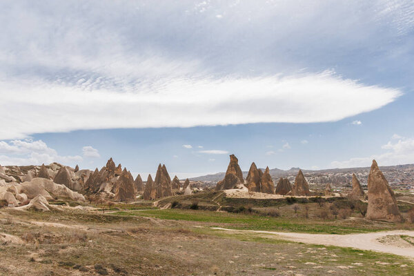 fairy chimneys at the valley in cappadocia on a partly cloudy day, landscape of the valley of cappadocia.