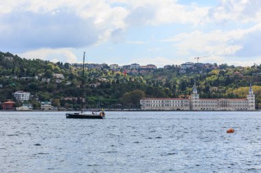 uskudar 'daki Boğaziçi ve Kuleli binasında yelkeni olmayan bir yat.
