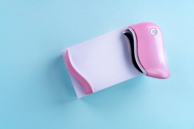 guasha cihazı ultrasonik masaj pembe mavi arka planda bir kozmetolog için parlak bir renk.