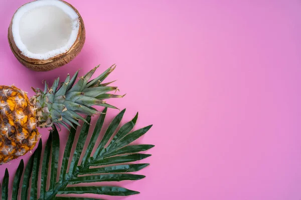 Tropické pozadí růžové s kokosovým ořechem a ananasem horní pohled — Stock fotografie