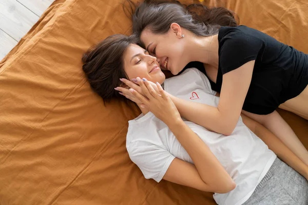 Lesbische vrouwen liggen op het dak knuffelen en lachen — Stockfoto