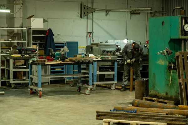 Człowiek pracuje w fabryce w pobliżu maszyny — Zdjęcie stockowe
