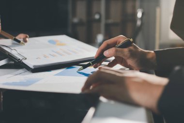 Gözlüklü yetenekli bir avukatla anlaşma imzalamaya odaklanmış genç bir işadamı. Konsantre mali danışman, ofiste erkek müşteriye sözleşme belgesinde imza yeri gösteriyor.