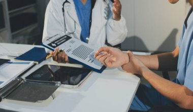 Genç esmer kadın doktor muayenehanesinde muayene oluyor.