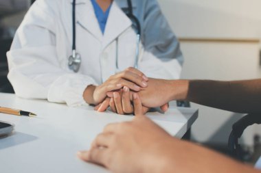 Doktor hastayı kontrol etmeye geldi ve cesaretlendirmek için elini sıktı. Hastanede tedavi edilenleri ve hastaları teselli etmek..