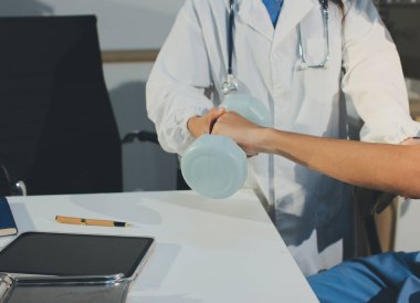 Hemşirenin desteğiyle el ağırlığı kullanan kişi