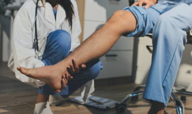 Fizyoterapist hastaya diz ağrısı için egzersiz yapmayı öğretiyor.