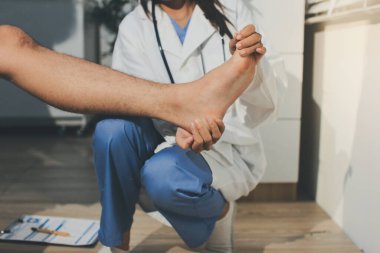 Fizyoterapist hastaya diz ağrısı için egzersiz yapmayı öğretiyor.