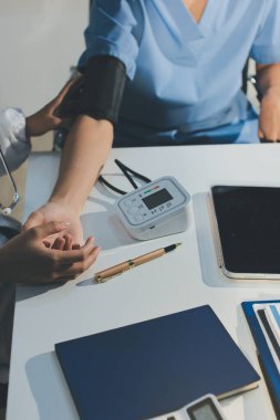 Hastanedeki hastanın kan basıncını ölçen doktor. Sağlık Hizmetleri Konsepti