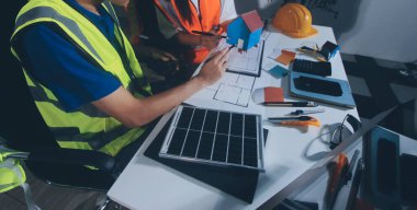 Endüstriyel mühendislerden oluşan bir ekip, fabrikadaki masada bulunan makine planlarını analiz ediyor. Fabrikada ya da üretim tesisinde çalışıyorum..