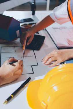 Endüstriyel mühendislerden oluşan bir ekip, fabrikadaki masada bulunan makine planlarını analiz ediyor. Fabrikada ya da üretim tesisinde çalışıyorum..