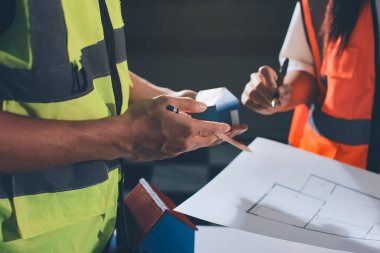 Endüstriyel mühendislerden oluşan bir ekip, fabrikadaki masada bulunan makine planlarını analiz ediyor. Fabrikada ya da üretim tesisinde çalışıyorum..