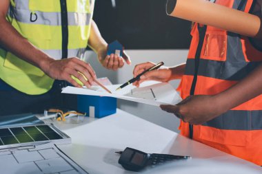 Endüstriyel mühendislerden oluşan bir ekip, fabrikadaki masada bulunan makine planlarını analiz ediyor. Fabrikada ya da üretim tesisinde çalışıyorum..