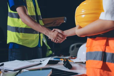 Endüstriyel mühendislerden oluşan bir ekip, fabrikadaki masada bulunan makine planlarını analiz ediyor. Fabrikada ya da üretim tesisinde çalışıyorum..