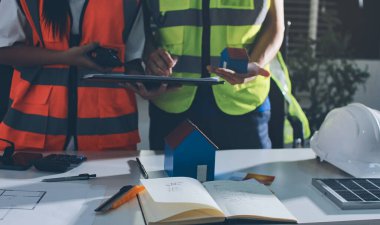 Endüstriyel mühendislerden oluşan bir ekip, fabrikadaki masada bulunan makine planlarını analiz ediyor. Fabrikada ya da üretim tesisinde çalışıyorum..