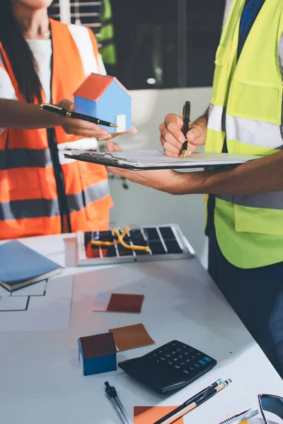 Endüstriyel mühendislerden oluşan bir ekip, fabrikadaki masada bulunan makine planlarını analiz ediyor. Fabrikada ya da üretim tesisinde çalışıyorum..