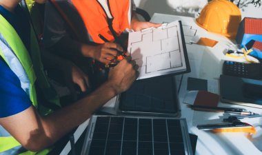 Endüstriyel mühendislerden oluşan bir ekip, fabrikadaki masada bulunan makine planlarını analiz ediyor. Fabrikada ya da üretim tesisinde çalışıyorum..