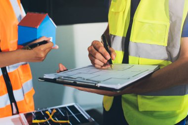 Endüstriyel mühendislerden oluşan bir ekip, fabrikadaki masada bulunan makine planlarını analiz ediyor. Fabrikada ya da üretim tesisinde çalışıyorum..
