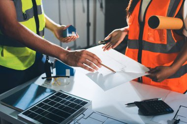 Endüstriyel mühendislerden oluşan bir ekip, fabrikadaki masada bulunan makine planlarını analiz ediyor. Fabrikada ya da üretim tesisinde çalışıyorum..