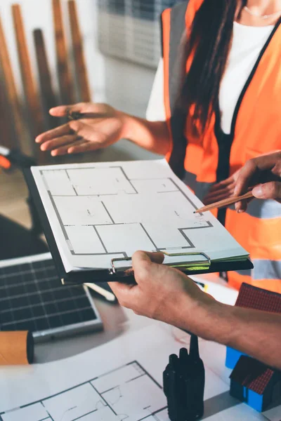 Endüstriyel mühendislerden oluşan bir ekip, fabrikadaki masada bulunan makine planlarını analiz ediyor. Fabrikada ya da üretim tesisinde çalışıyorum..