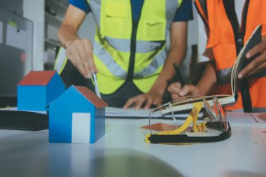 Endüstriyel mühendislerden oluşan bir ekip, fabrikadaki masada bulunan makine planlarını analiz ediyor. Fabrikada ya da üretim tesisinde çalışıyorum..