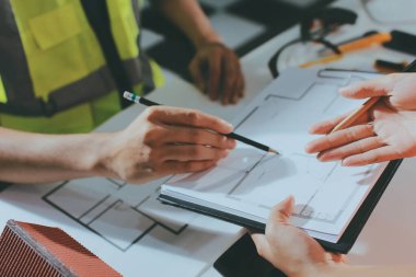 Endüstriyel mühendislerden oluşan bir ekip, fabrikadaki masada bulunan makine planlarını analiz ediyor. Fabrikada ya da üretim tesisinde çalışıyorum..