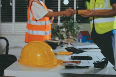 Endüstriyel mühendislerden oluşan bir ekip, fabrikadaki masada bulunan makine planlarını analiz ediyor. Fabrikada ya da üretim tesisinde çalışıyorum..