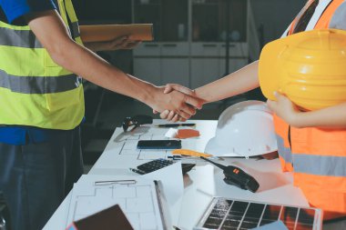Endüstriyel mühendislerden oluşan bir ekip, fabrikadaki masada bulunan makine planlarını analiz ediyor. Fabrikada ya da üretim tesisinde çalışıyorum..