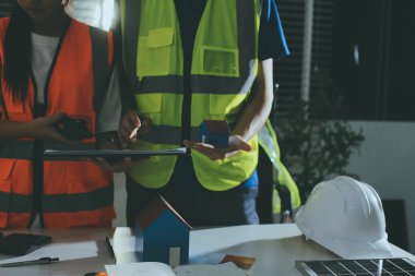 Endüstriyel mühendislerden oluşan bir ekip, fabrikadaki masada bulunan makine planlarını analiz ediyor. Fabrikada ya da üretim tesisinde çalışıyorum..