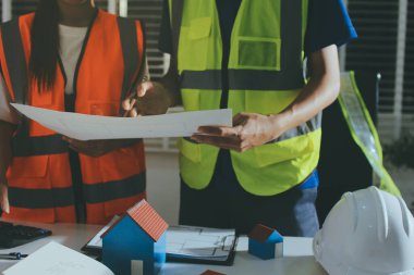 Endüstriyel mühendislerden oluşan bir ekip, fabrikadaki masada bulunan makine planlarını analiz ediyor. Fabrikada ya da üretim tesisinde çalışıyorum..