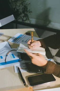 İşadamlarının yakın çekimleri notlar, cep telefonları, çizelgeler, masa, ofis