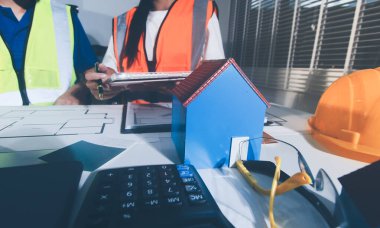 Endüstriyel mühendislerden oluşan bir ekip, fabrikadaki masada bulunan makine planlarını analiz ediyor. Fabrikada ya da üretim tesisinde çalışıyorum..