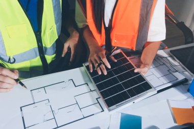 Endüstriyel mühendislerden oluşan bir ekip, fabrikadaki masada bulunan makine planlarını analiz ediyor. Fabrikada ya da üretim tesisinde çalışıyorum..