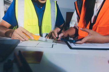 Endüstriyel mühendislerden oluşan bir ekip, fabrikadaki masada bulunan makine planlarını analiz ediyor. Fabrikada ya da üretim tesisinde çalışıyorum..