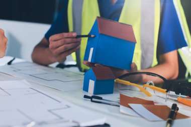 Endüstriyel mühendislerden oluşan bir ekip, fabrikadaki masada bulunan makine planlarını analiz ediyor. Fabrikada ya da üretim tesisinde çalışıyorum..