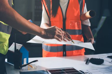 Endüstriyel mühendislerden oluşan bir ekip, fabrikadaki masada bulunan makine planlarını analiz ediyor. Fabrikada ya da üretim tesisinde çalışıyorum..