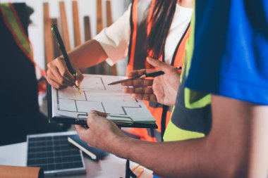 Endüstriyel mühendislerden oluşan bir ekip, fabrikadaki masada bulunan makine planlarını analiz ediyor. Fabrikada ya da üretim tesisinde çalışıyorum..