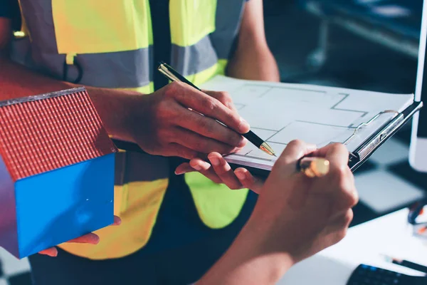 Endüstriyel mühendislerden oluşan bir ekip, fabrikadaki masada bulunan makine planlarını analiz ediyor. Fabrikada ya da üretim tesisinde çalışıyorum..