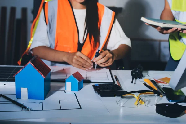 Endüstriyel mühendislerden oluşan bir ekip, fabrikadaki masada bulunan makine planlarını analiz ediyor. Fabrikada ya da üretim tesisinde çalışıyorum..