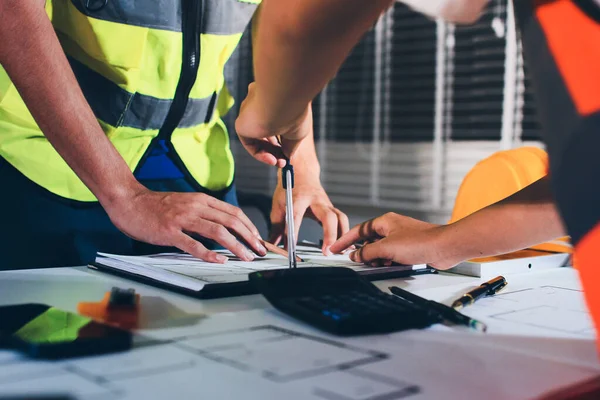 Endüstriyel mühendislerden oluşan bir ekip, fabrikadaki masada bulunan makine planlarını analiz ediyor. Fabrikada ya da üretim tesisinde çalışıyorum..