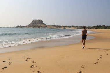 Genç turist kız Yala Milli Parkı'nda plajda yürüyor