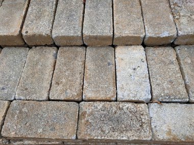 Yeni, kaba desenli dikdörtgen blok yığınının yakın plan bir görüntüsü, doğal, toprak renklerini sergiliyor ve inşaat, patikalar veya peyzaj projeleri için detaylı yüzey.