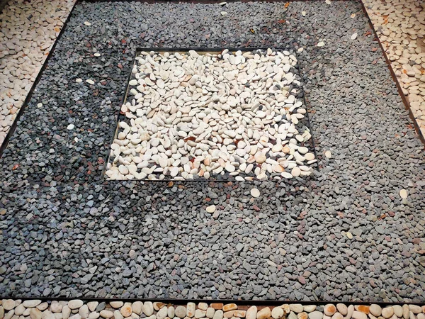 Temiz, yatay bir çizgi, açık renkli, pürüzsüz nehir taşlarının bir kısmını daha koyu ve çeşitli çakıl taşlarından ayırır..