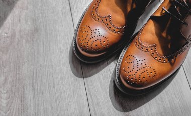 Ahşap zeminde zarif kahverengi ayakkabılar.