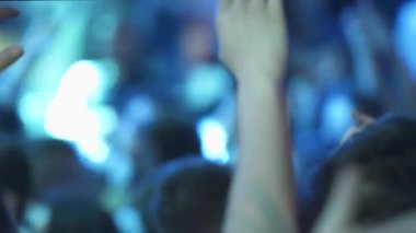 Konserdeki insanlar, canlı müzik etkinliğinde tezahürat ve tezahürat yapıyorlar..